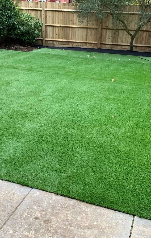 Beautiful artificial lawn with wooden fencing